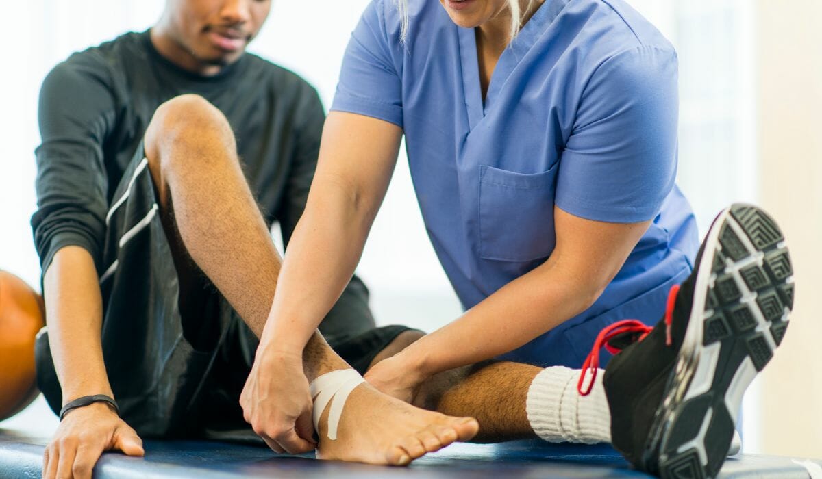 A Physical Therapist Binding Foot of Clients